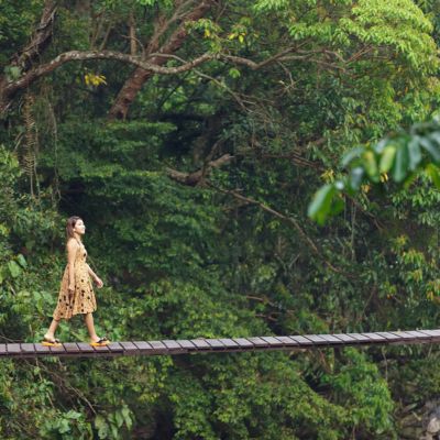 Tobassa (2) Person walking across swing bridge in green jungle