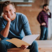 man sitting reading hand on chin man sitting reading hand on chin